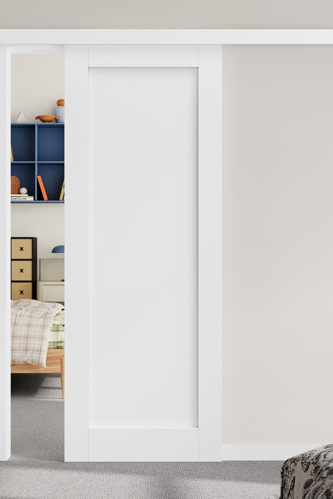 Modern white sliding barn door partially open, revealing a glimpse of a colorful, organized bedroom with blue shelving and a plaid-patterned bed.