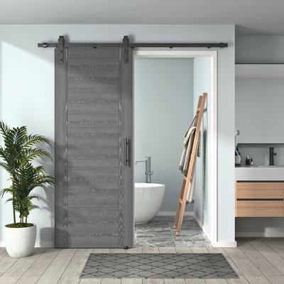 DOOR HARBOR 24in x 80in Pre-Assembled Sliding Barn Door with 4.5ft ALL-IN-ONE Black Hardware Kit, 5-Panel Flush Design, Solid Core, Grey Oak Primed, with One-Piece Track, Handle and Lock