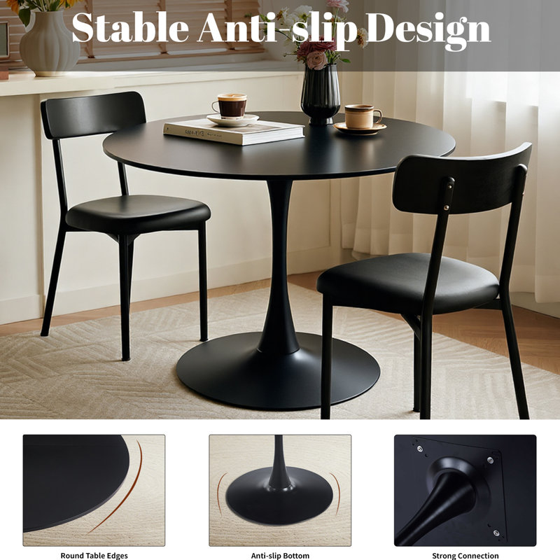 Une table de salle à manger ronde de style luxueux et noire, équipée d'une élégante base en métal en forme de tulipe et d'un plateau en panneau de fibres à densité moyenne de 31,5 pouces, présente un style médiéval moderne dans son ensemble. It