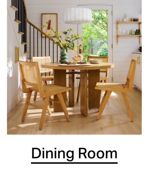Round oak dining table with cane back chairs in a bright, modern dining room. Dining Room.