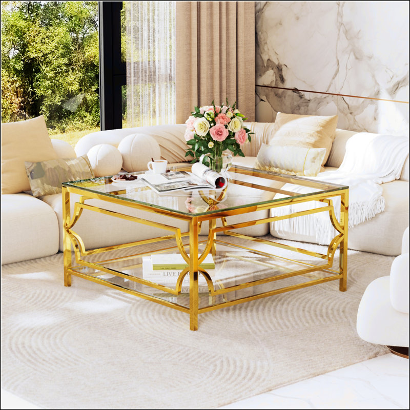 Table basse carrée en verre avec structure luxueuse en métal géométrique, finition dorée et tablette inférieure fonctionnelle