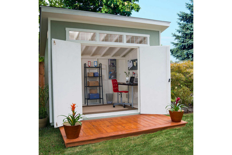She shed with open double doors, a small deck, and a workspace.