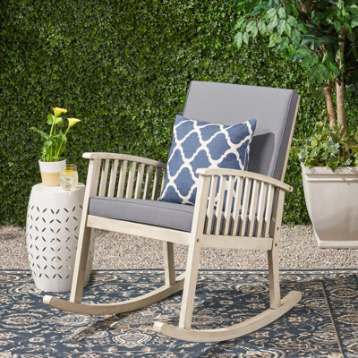 Chaise berçante en bois gris pour un moment paisible en plein air
