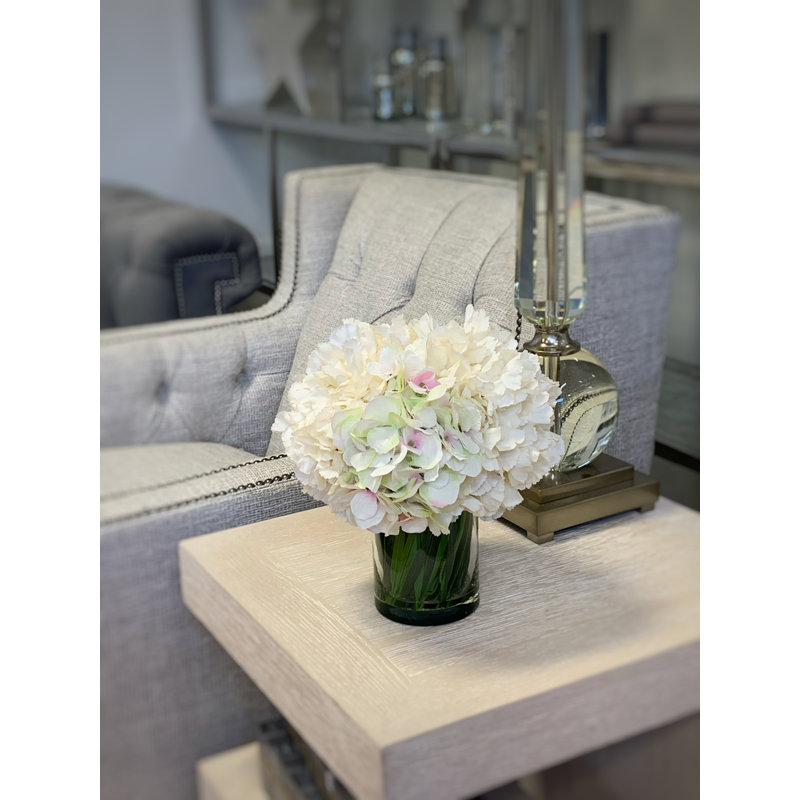 Arrangement floral d'hortensias dans un vase en verre avec de l'herbe