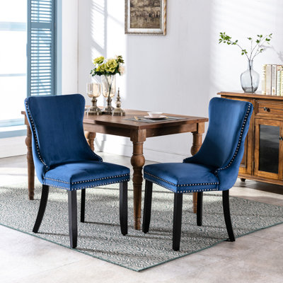 Chaise de salle à manger rembourrée en velours bleu, pieds en bois massif, garniture cloutée à surpiqûres, chaises 2 pièces de style moderne et confortable, détail, look chaleureux et invitant