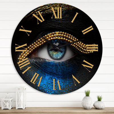 Femme aux yeux avec une chaîne en or et un pigment bleu - horloge murale moderne