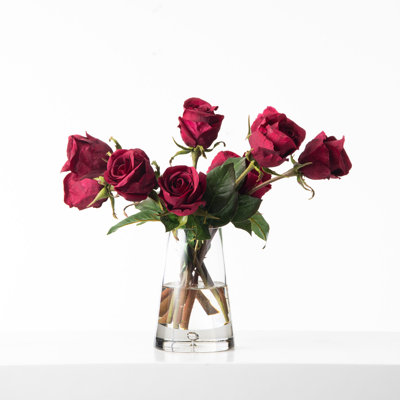Arrangement floral toutes saisons avec boutons de roses bourgogne rouge dans un vase en verre pyramide en forme de goutte d'eau