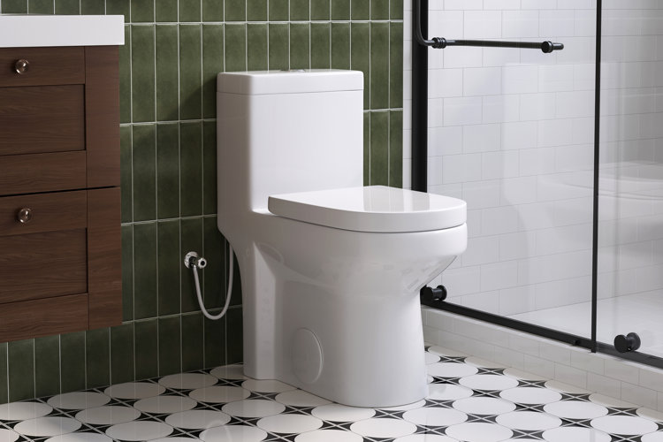 white one-piece toilet in a green bathroom with patterned floor tile and a floating vanity