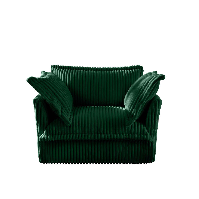 Fauteuil confortable recouvert de plusieurs coussins moelleux et assise profonde, Vert