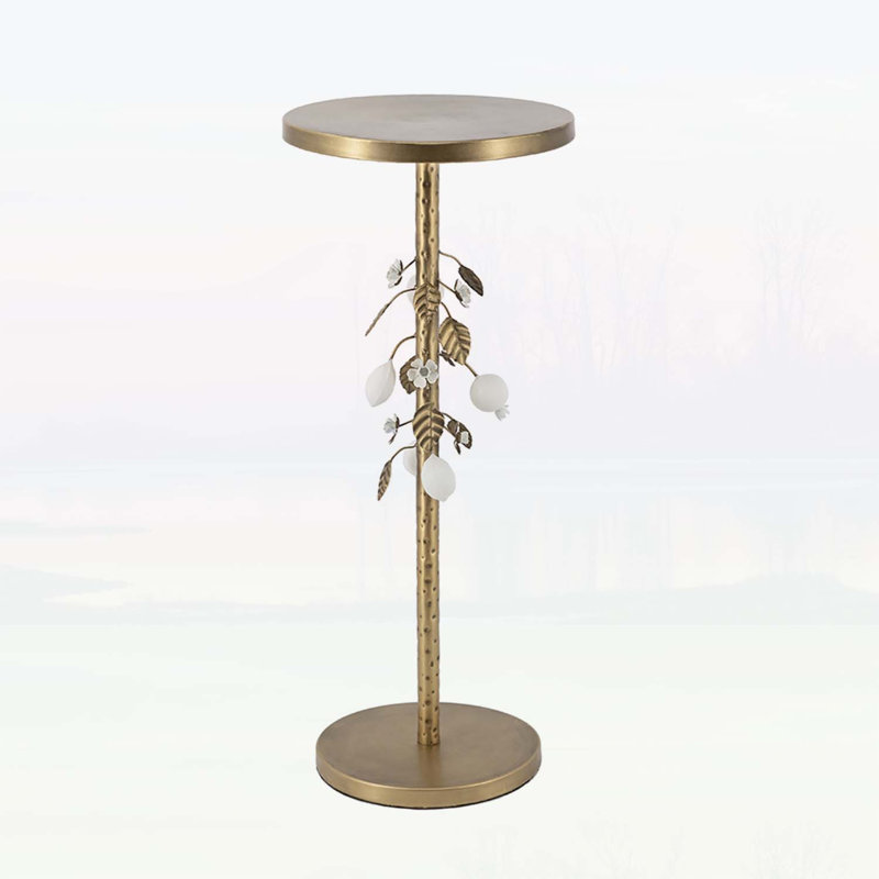 Table d'appoint ronde en fer avec accents floraux dorés et blancs, base en ciment et détails botaniques élégants pour les intérieurs modernes