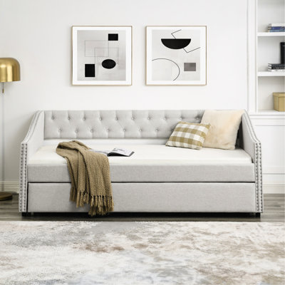 Lit de jour confortable avec lit gigogne, rembourrage beige, dossier et accoudoirs cloutés en cuivre brillant beige, délicat