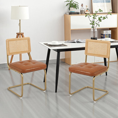 Ensemble de 2 chaises de salle à manger cantilever en rotin, assise capitonnée en similicuir, structure en acier doré, idéales pour la cuisine et la salle à manger.