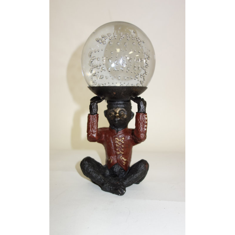 Sculpture de singe assis tenant un plateau avec boule de verre