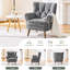 Fauteuil à oreilles capitonné avec accoudoirs roulés et coussins épais.-309566086