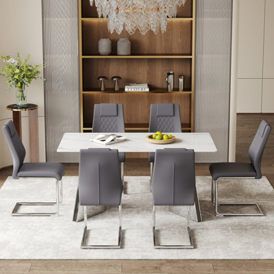 Ensemble de table et de chaises. Luxueuse table en pierre frittée à motif montagne de neige de 63 po x 31,5 po x 30 po avec pieds papillon en métal argenté.