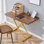 La table élévatrice multifonctionnelle moderne et minimaliste avec un bureau en panneau de fibres à densité moyenne de 0,8 pouce d'épaisseur et des pieds en métal doré peut être utilisée comme coiffeuse, table basse, table de salle à manger et table de bureau. Bureau texturé noyer