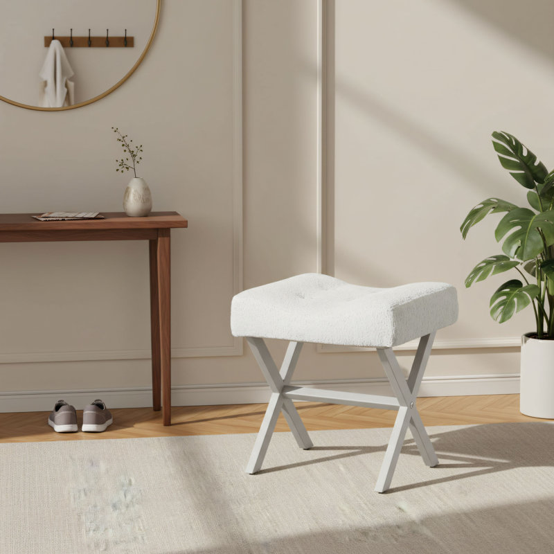 Grand tabouret blanc en forme de selle avec pieds en X en métal et revêtement en velours moelleux et respirant.