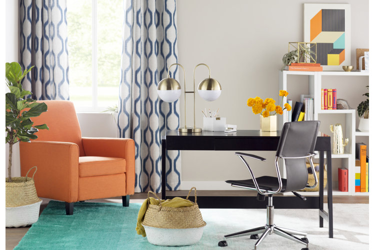 modern home office with a teal gradient area rug under a black writing desk and an orange arm chair