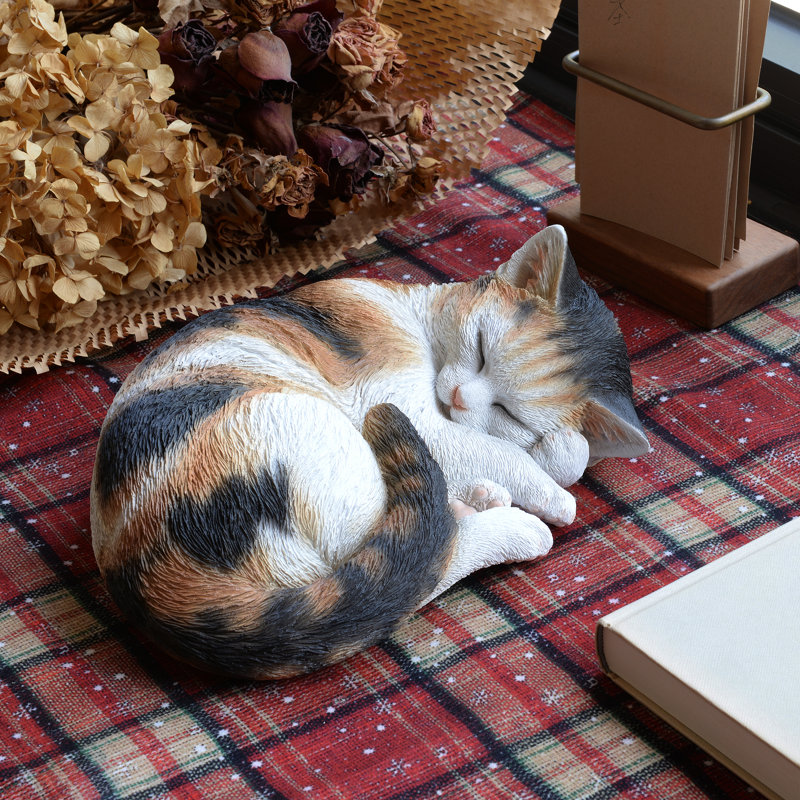 Statue de chat calicot endormi