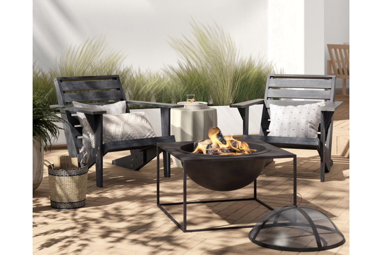 Black wooden patio furniture around a wood burning fire pit.