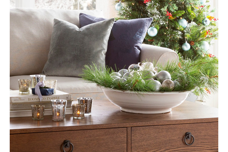 Decorative bowl filled with evergreen branches and Christmas ball ornaments.