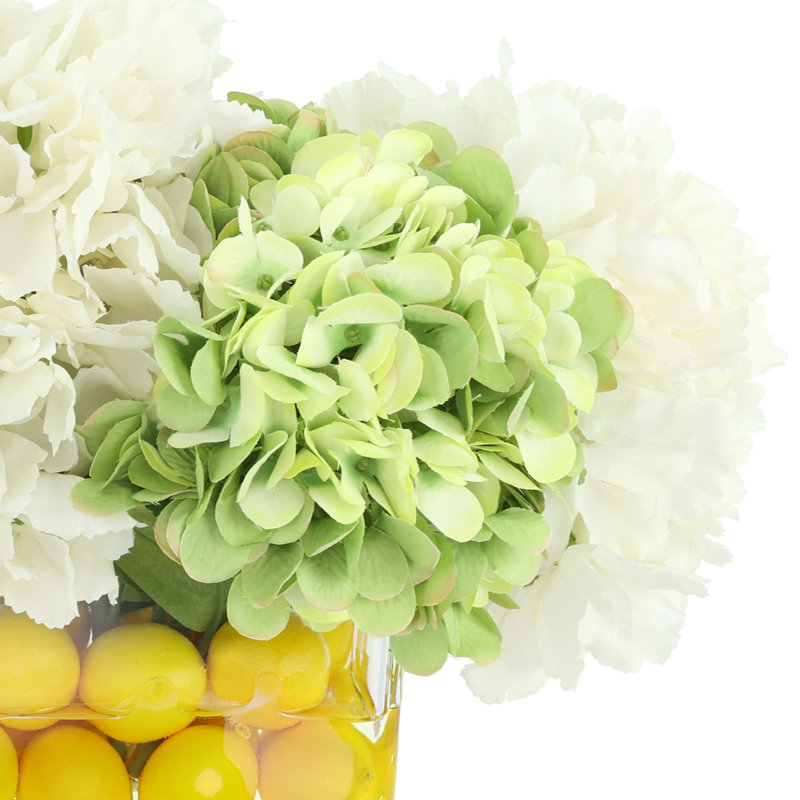 Hortensias disposés dans un vase ovale avec des citrons