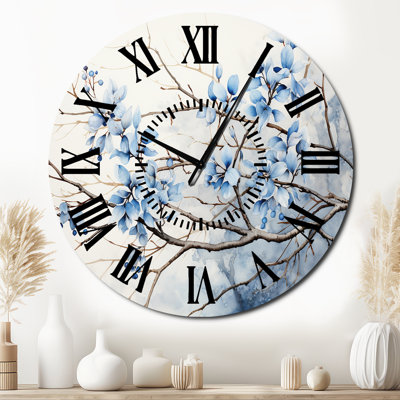 Horloge murale bleue et grise avec feuilles sur une branche