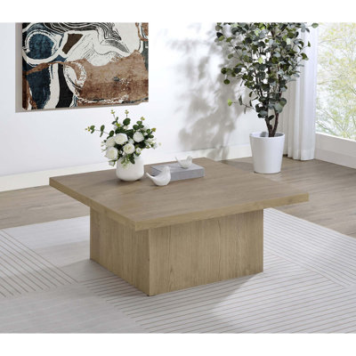 Table basse moderne carrée avec plateau épais et base piédestal