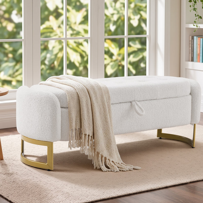 Banc de rangement capitonné Teddy avec pieds en fer courbés, structure en bois massif et plateau relevable à languette.