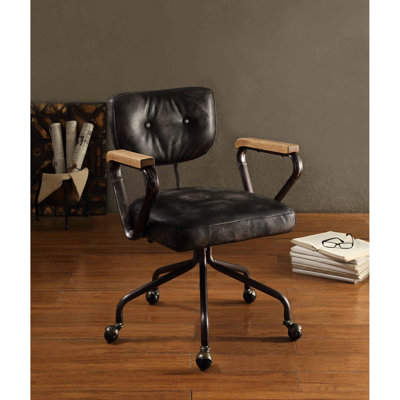 Fauteuil vintage en cuir noir - Dossier mi-haut capitonné, accoudoirs rembourrés, assise pivotante confortable, piètement inclinable en métal, assise en bois fixe, style élégant avec garniture cloutée.