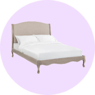 Classic French style upholstered bed with white bedding on lilac background