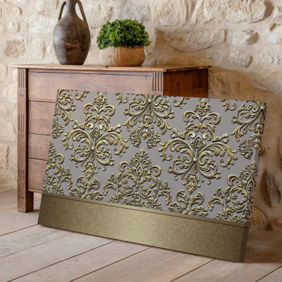 La toile crée un design de papier peint élégant avec un motif damassé complexe en or chatoyant contre un taupe doux