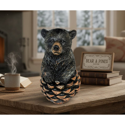 Figurine ours rustique assis sur une pomme de pin