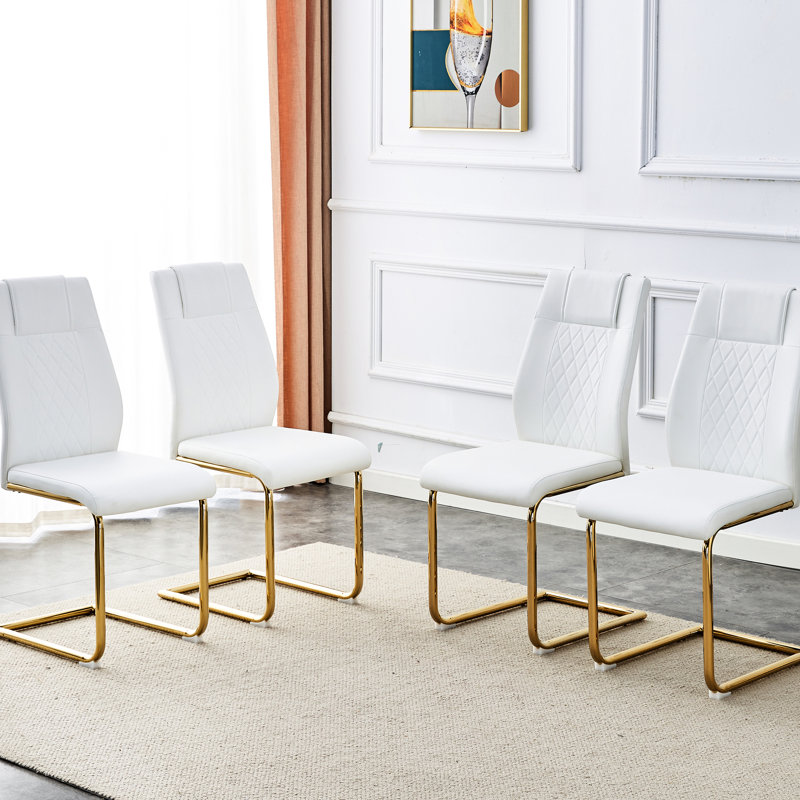 Ogilvie comprend 4 chaises capitonnées en PU blanches avec des pattes dorées, offrant une option de détente et d'élégance pour diverses pièces.