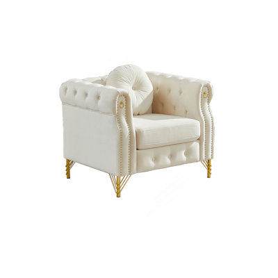 Velvet Chesterfield sofa with round pillows, featuring copper stud detailing and tufted button accents, with metal legs. Loop design allows for hanging cartoon ornaments.
