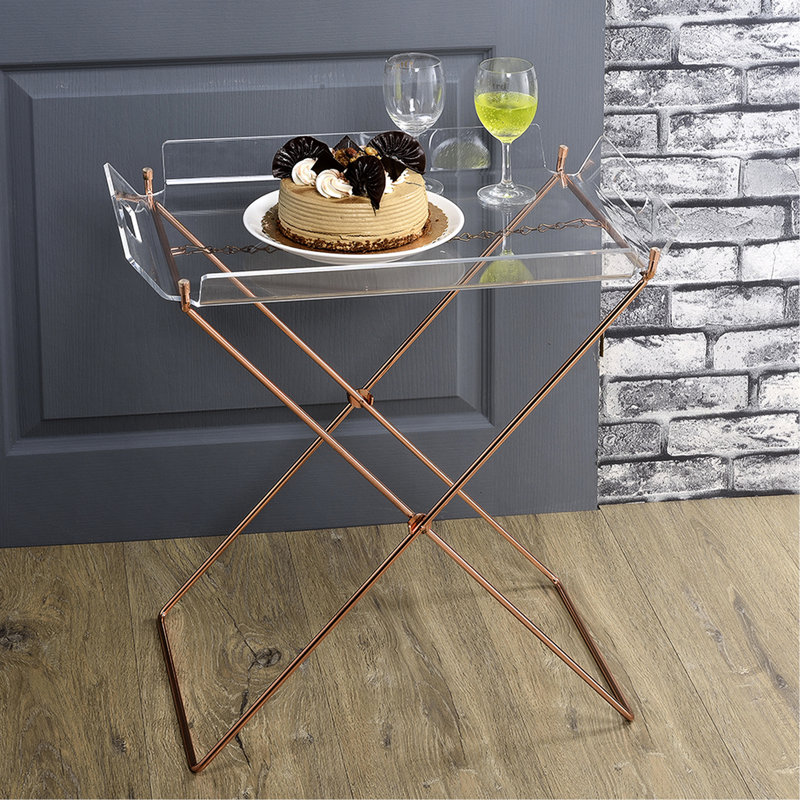 Table d'appoint contemporaine en acrylique transparent avec un solide piètement en cuivre et un design en forme de « X » en métal, idéale pour le salon.