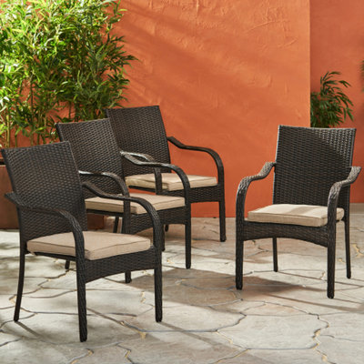 Ensemble de 4 chaises empilables d'extérieur avec coussins et accoudoirs incurvés, résine marron, structure en fer, profondeur 61,5 cm, largeur 74,8 cm, hauteur 87,6 cm.