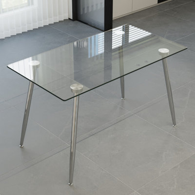 Table de salle à manger moderne en verre avec pieds en métal