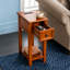 Table d'appoint compacte en bois massif avec station de charge et tiroir intégrés, parfaite pour les petits espaces et les chambres à coucher modernes.