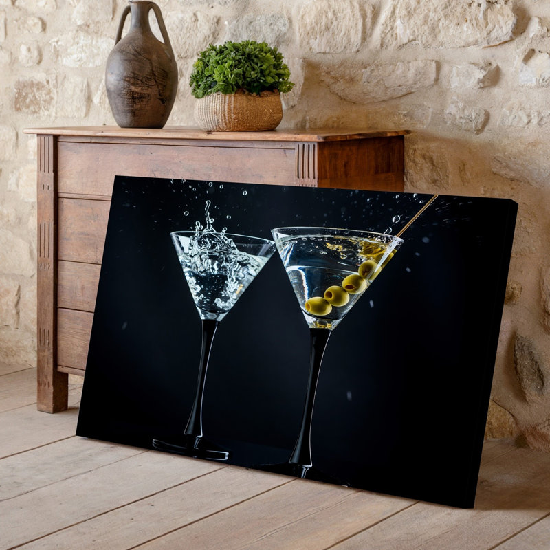 Toile Deux élégants verres à martini remplis de liquide chatoyant transparent contenant des olives vertes sont placés contre une toile
