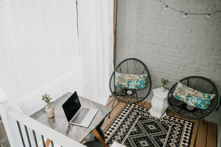 Throw pillows, laptop & coffee table on front porch