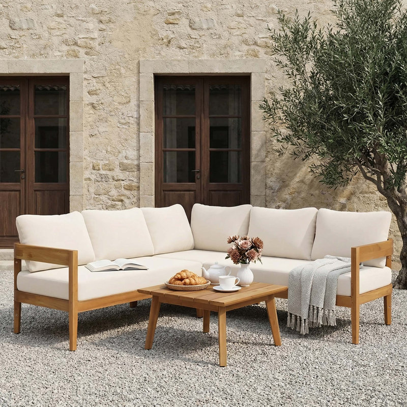 Ensemble de conversation quatre pièces pour canapé d'extérieur avec structure en bois d'acacia, coussins beiges hydrofuges, conception à lattes et silhouette arrondie de smoking pour une utilisation moderne et durable du patio.