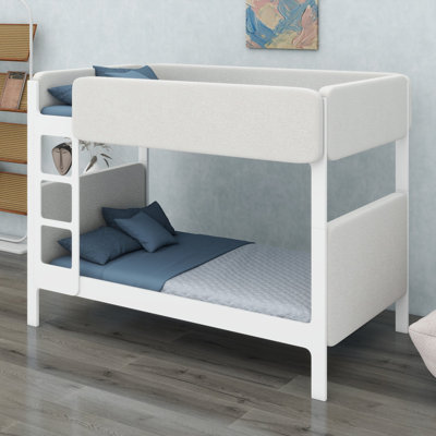 Un lit superposé avec une tête de lit, un pied de lit et des garde-corps rembourrés épais ancrent une chambre à coucher moderne et confortable