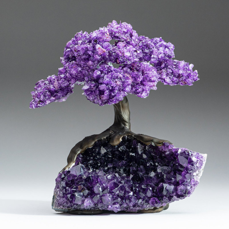 Amethyst gemstone tree sculpture with purple crystal foliage on a geode cluster base