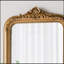 Miroir mural arqué 23,5 x 37,5 po avec écusson doré orné, parfait pour rehausser tout style intérieur et ajouter une touche d'élégance