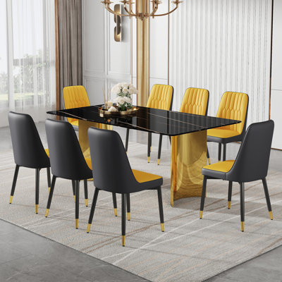 Ensemble de table et de chaises. La table a un plateau en verre avec des autocollants en imitation marbre et des pieds dorés en acier inoxydable. Assorti avec 8 chaises de salle à manger en polyuréthane épissé orange et gris foncé.