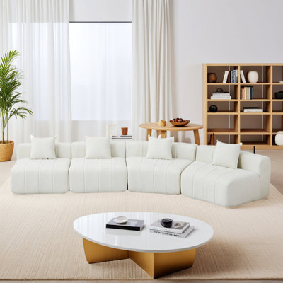 Canapé modulaire courbé avec quatre coussins pour les espaces de vie modernes.