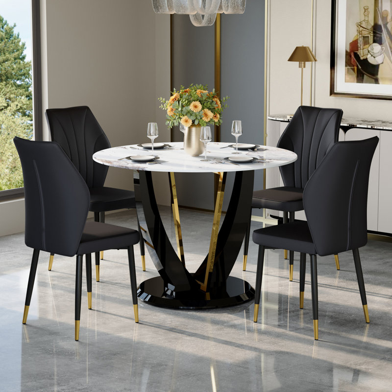 Ensemble de table et de chaises.Une table de salle à manger ronde en verre trempé Pandora de 42 po de diamètre avec pieds en panneau de fibres à densité moyenne en forme de V. Elle est dotée de 4 chaises en polyuréthane noir avec un dossier élargi.