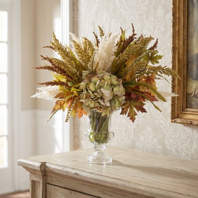 Chute d'automne et arrangement de pampas dans un vase en verre piédestal