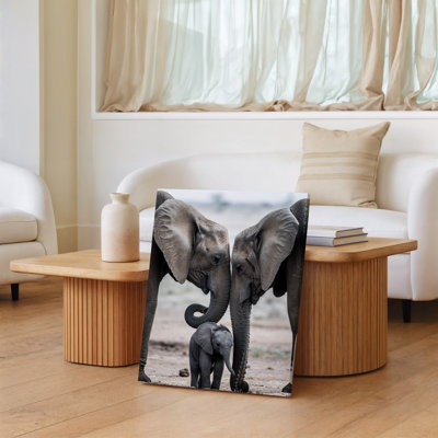 Canvas A Tender Scene Featuring Two Adult Elephants Gently Touching Foreheads Wall Art With A Playful Baby Elephant Nestled Between Canvas Wall Art